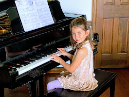A young music student sits at a piano.