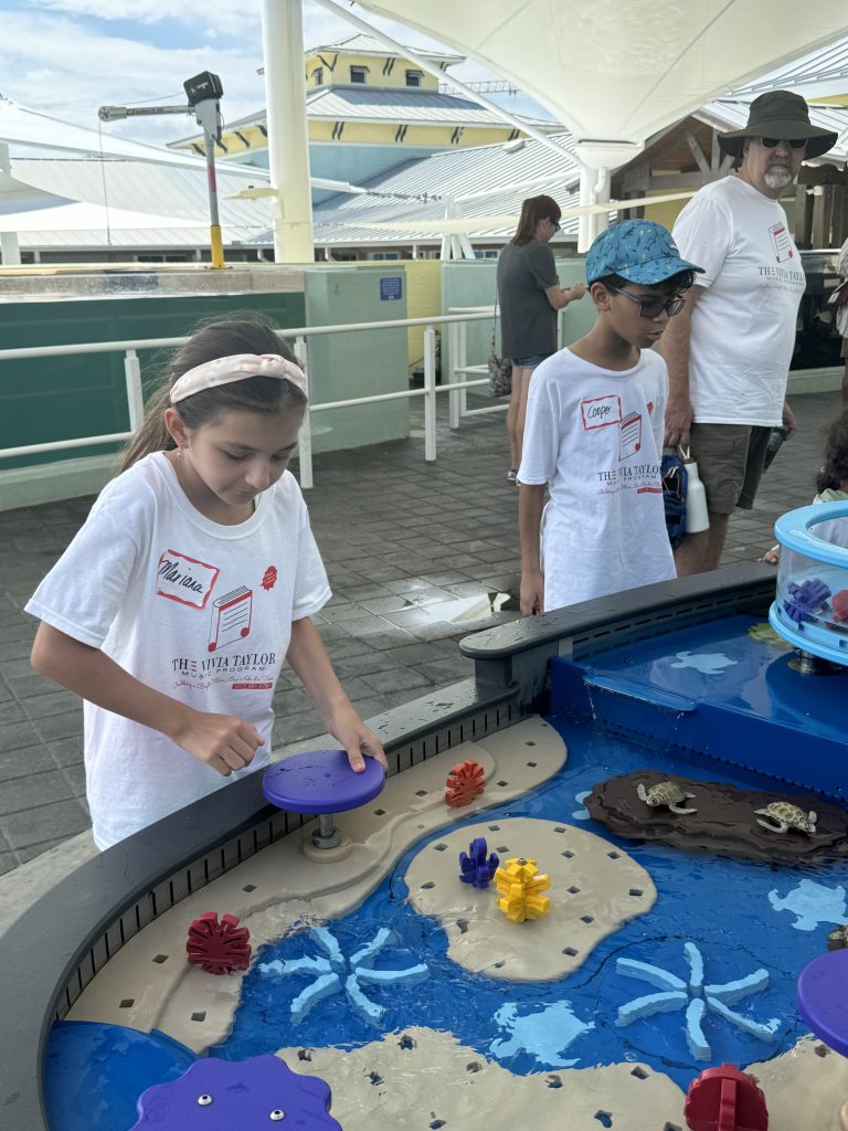 A young music student interacts with a display at the Loggerhead Marinelife Center.