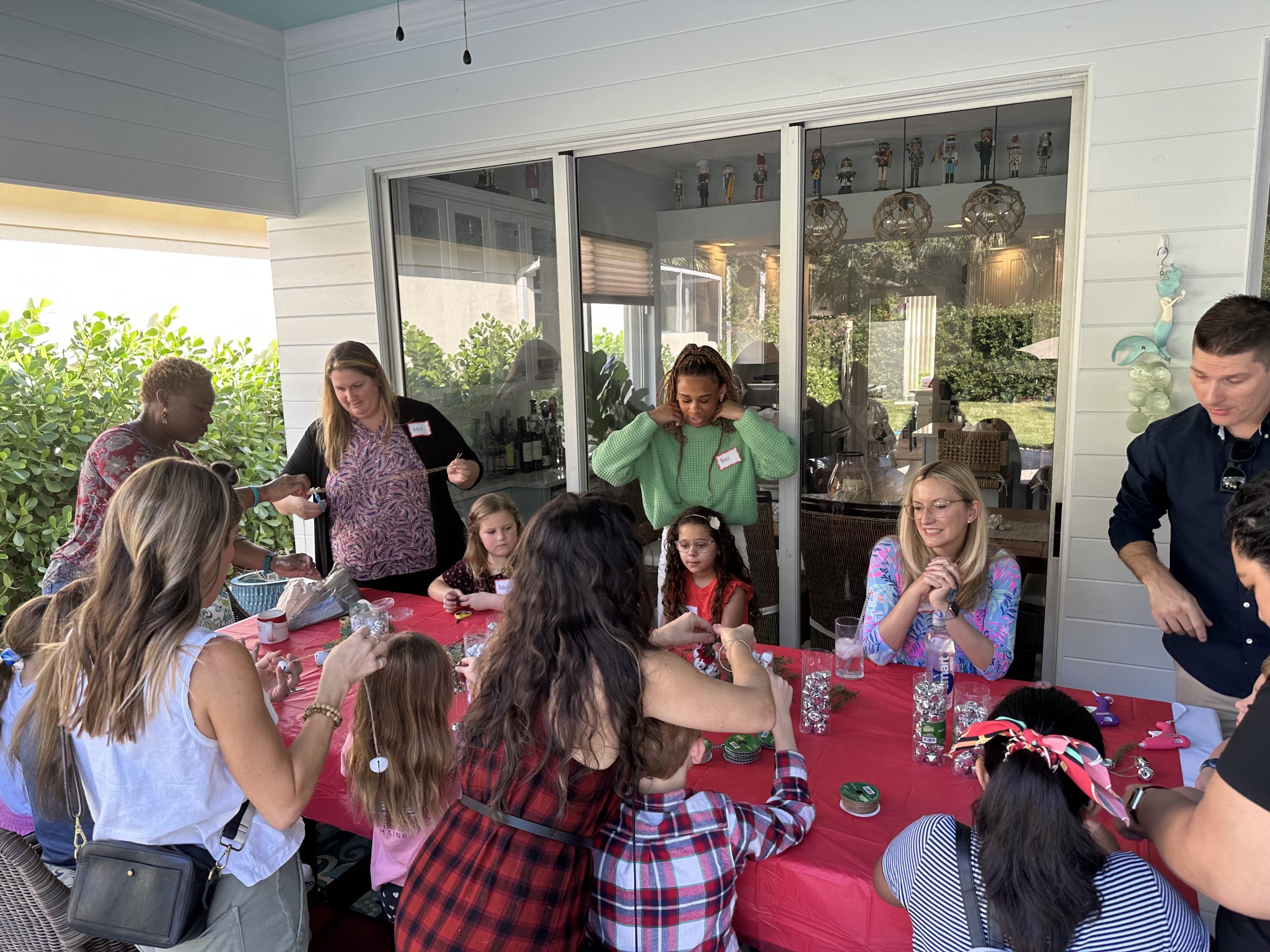 Music students and their families sit together at a table crafting Christmas decorations.