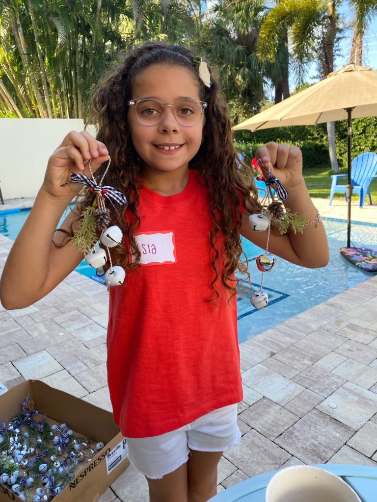 A young student of the Vivia Taylor Music Program holds up Christmas decorations.
