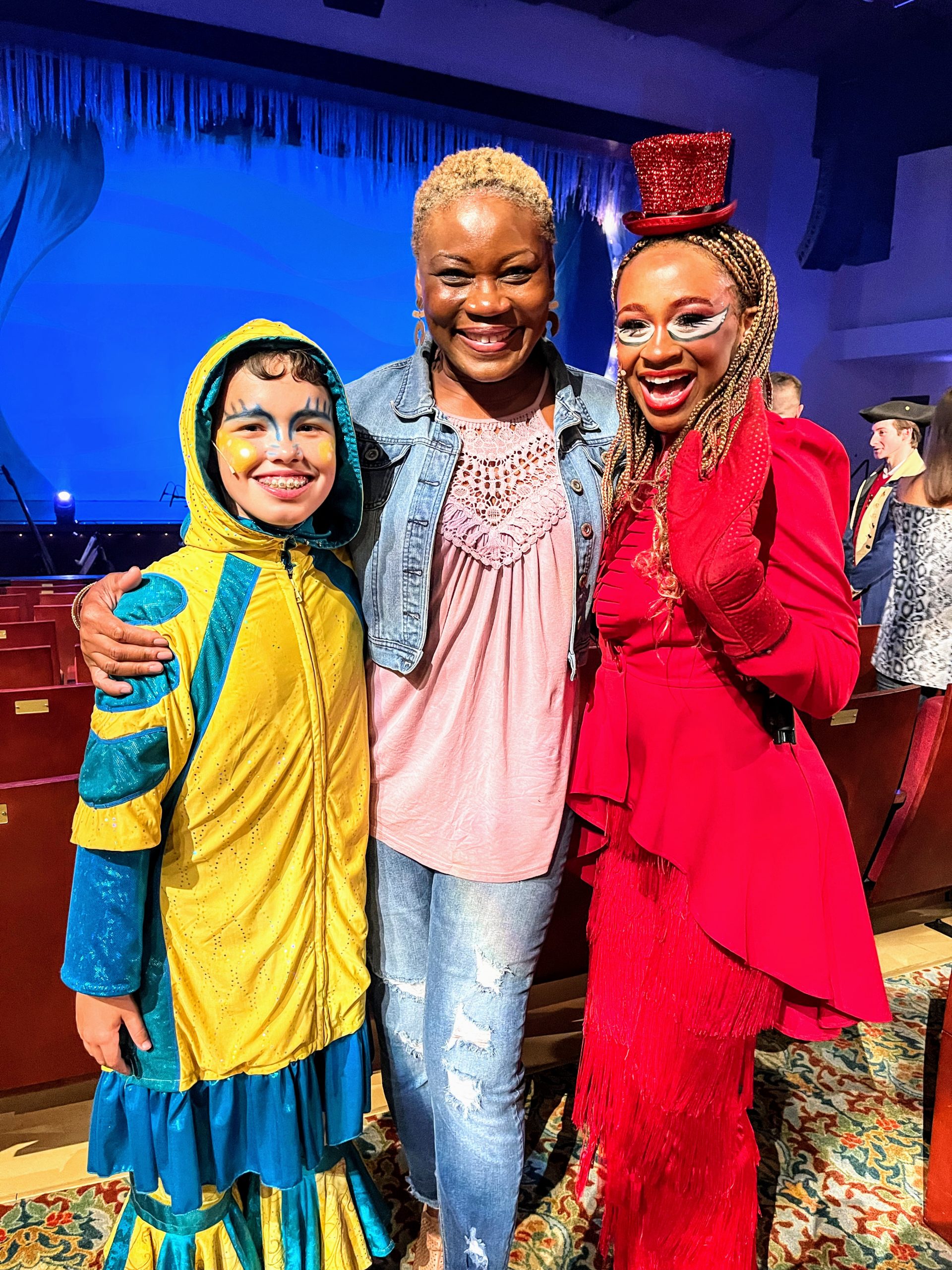 Music teacher Vivia Taylor stands with two students in costumes