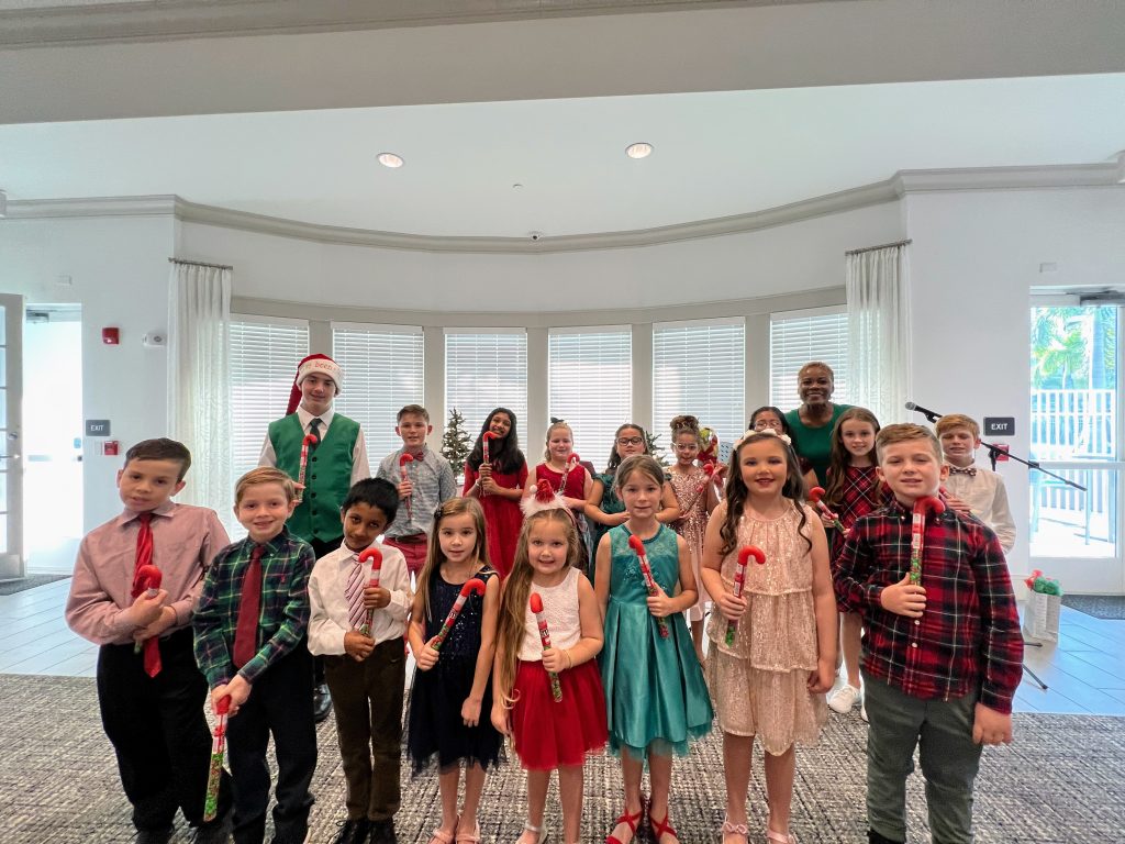 A group of music students stand with their teacher Vivia Taylor at a Christmas recital