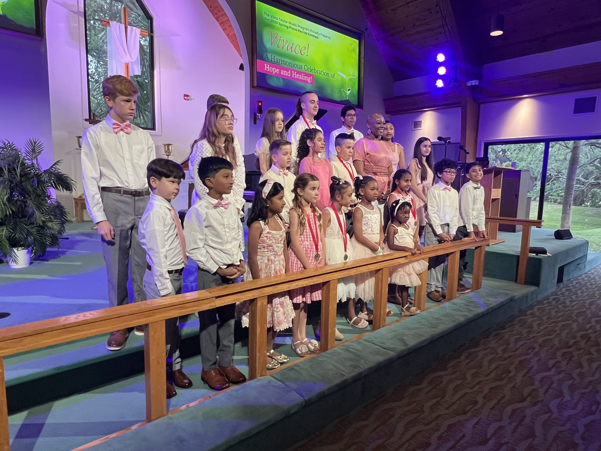Vivia Taylor with a group of her students singing in a church during a recital.