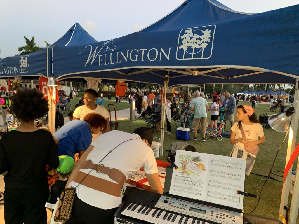 Music Teacher Vivia Taylor talks to people at her table at the Wellington Green Market.