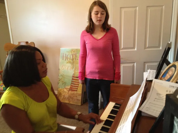 Vivia Taylor accompanies a student on piano at a voice lesson.