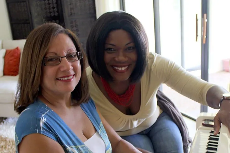 Vivia Taylor sits at a piano with an adult student.