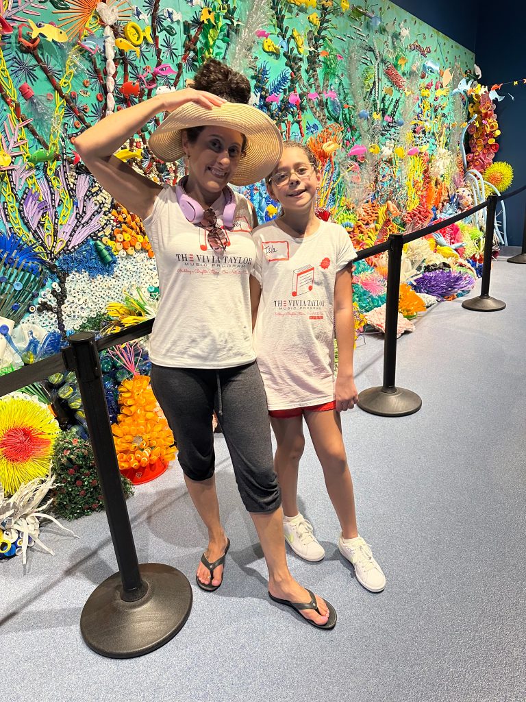 A music student and her mother in front of a mural at the Loggerhead Marinelife Center.