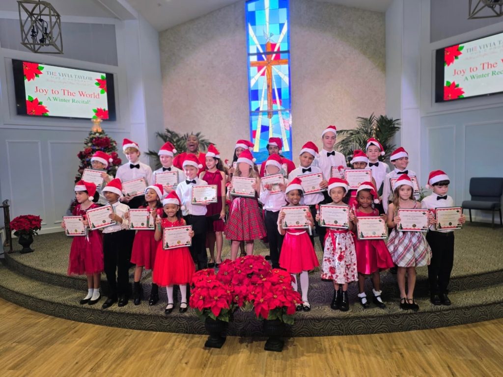 Vivia Taylor's students pose in a group at the 2025 Winter Recital while holding certificates.