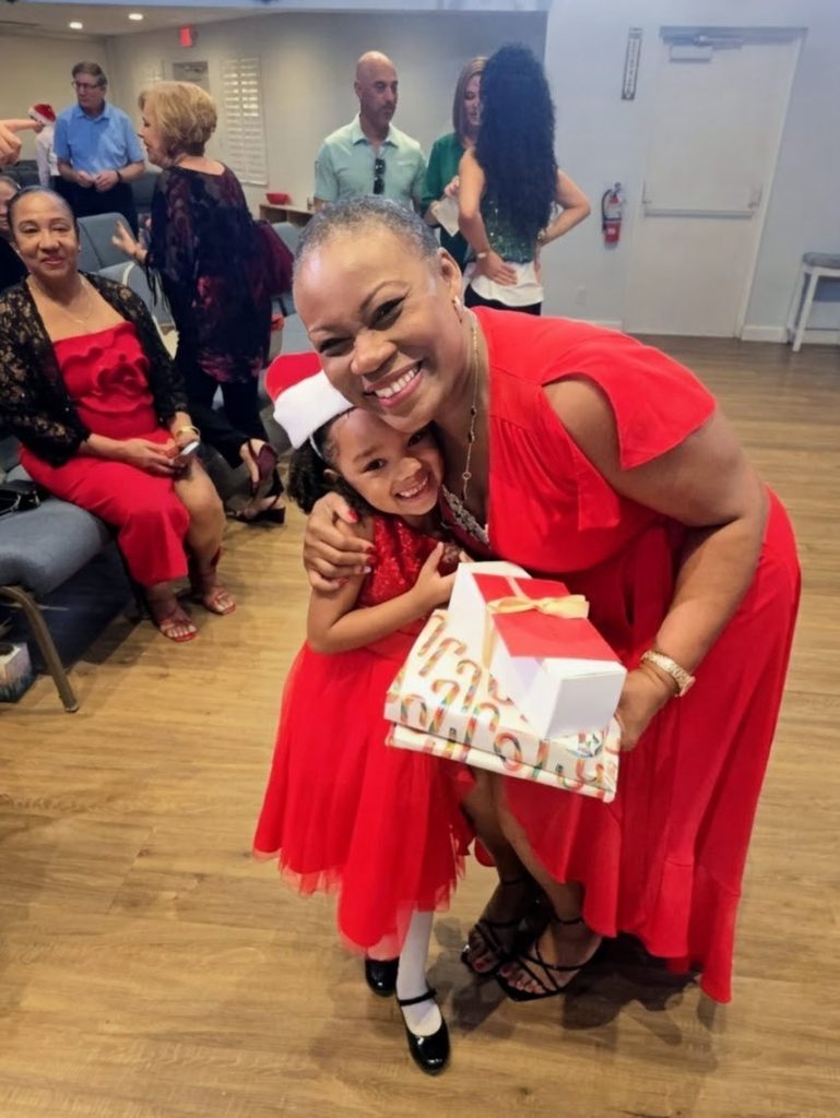 Music teacher Vivia Taylor hugs a student at the 2025 Winter Recital.