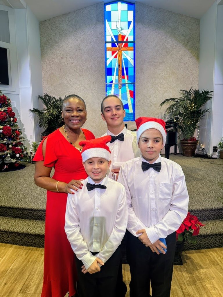 Music teacher Vivia Taylor stands with three students at the 2025 Winter Recital.